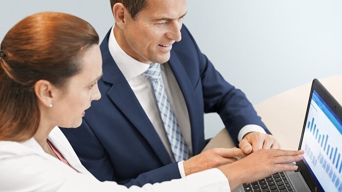 Three people at a business meeting listening to one give a presentation