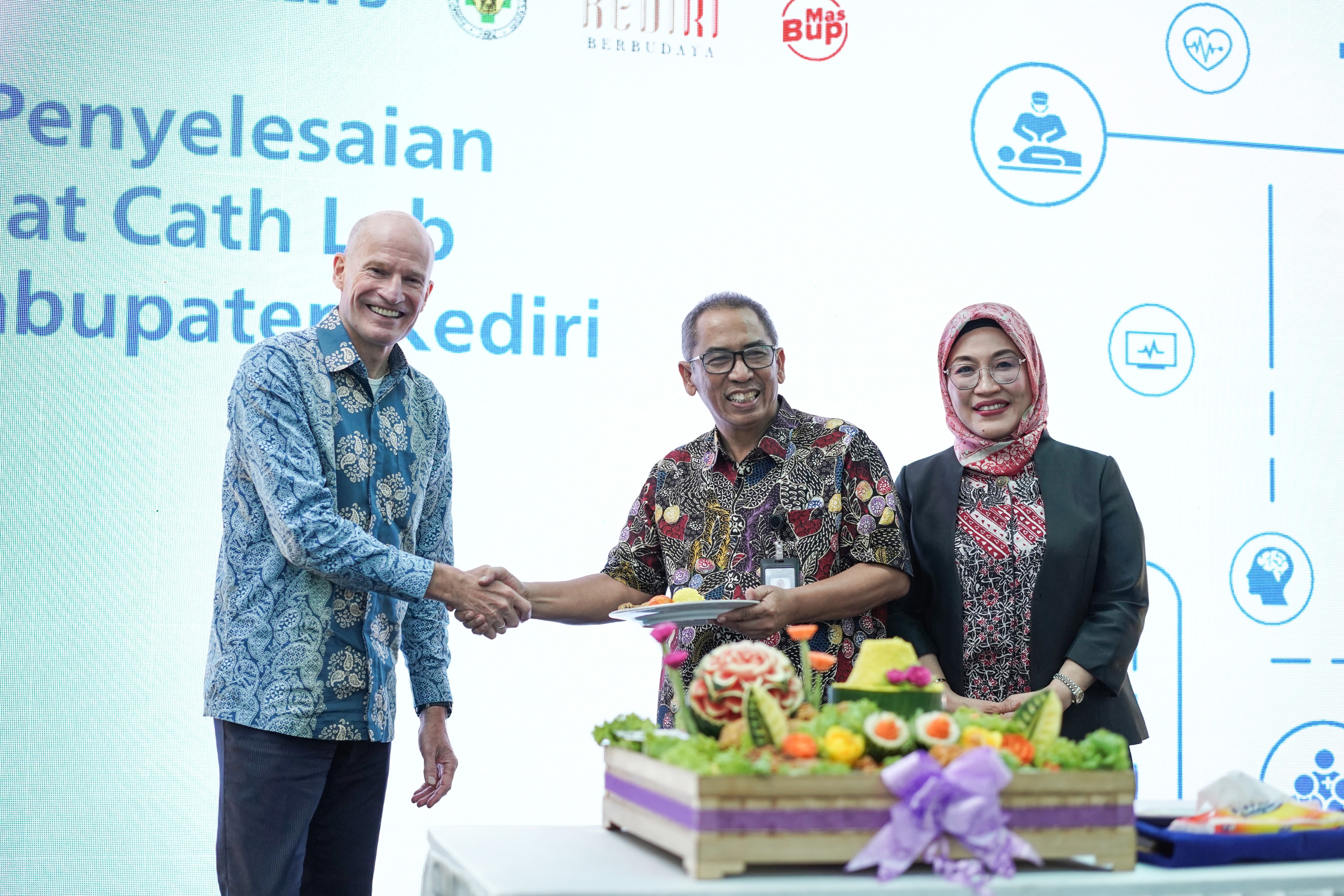 Presentation of the &lsquo;tumpeng&rsquo; by Bert van Meurs, Executive Vice President and Chief Business Leader for Image-Guided Therapy at Philips, to the Director of Kediri Regency General Hospital, Dr. R. Gatut Rahardjo, Sp.An, accompanied by Astri Ramayanti Dharmawan, President Director of Philips Indonesia.